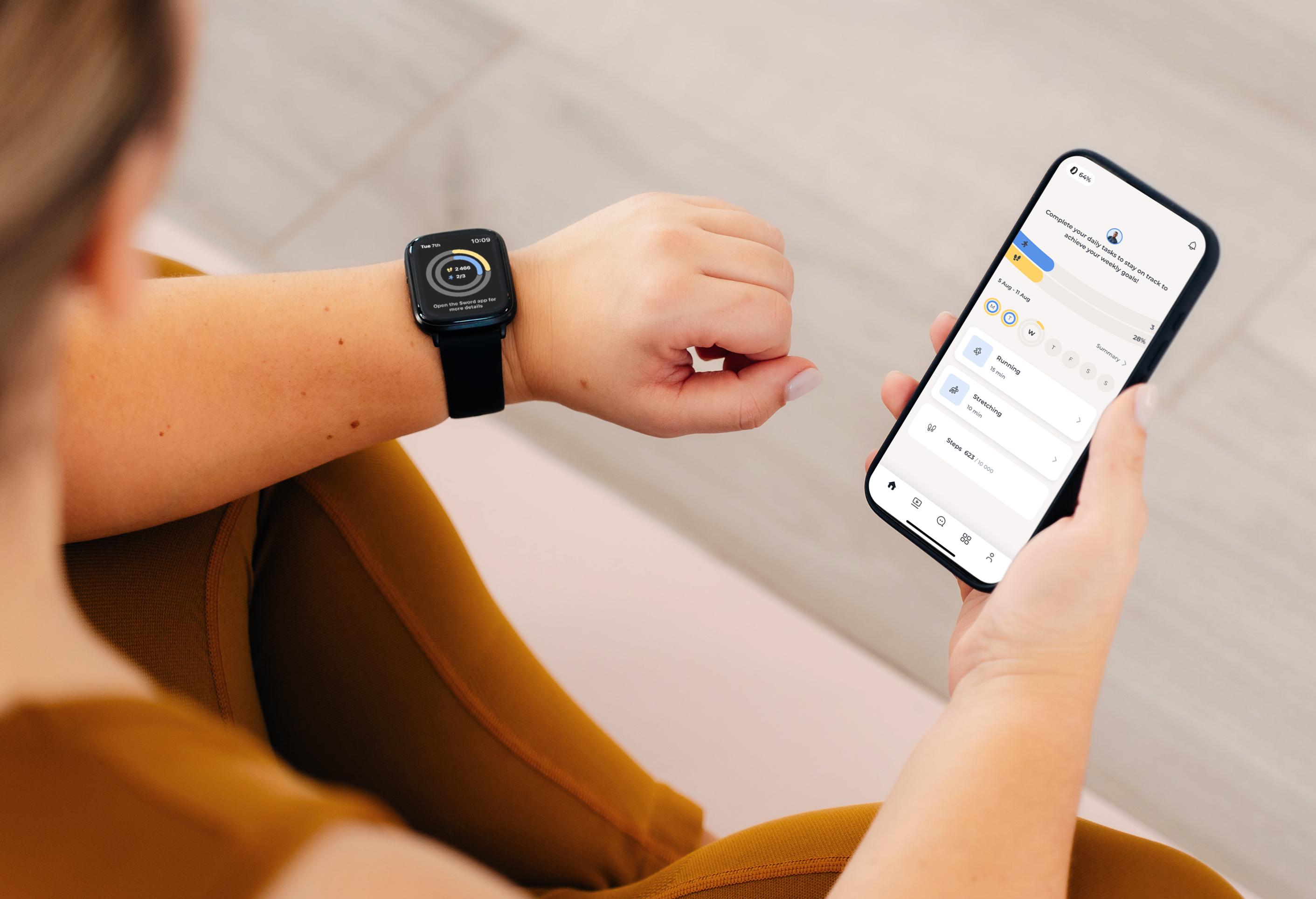 Person checking fitness stats on a Move Wearable smartwatch and smartphone, both displaying health data. They're seated, wearing a brown outfit.